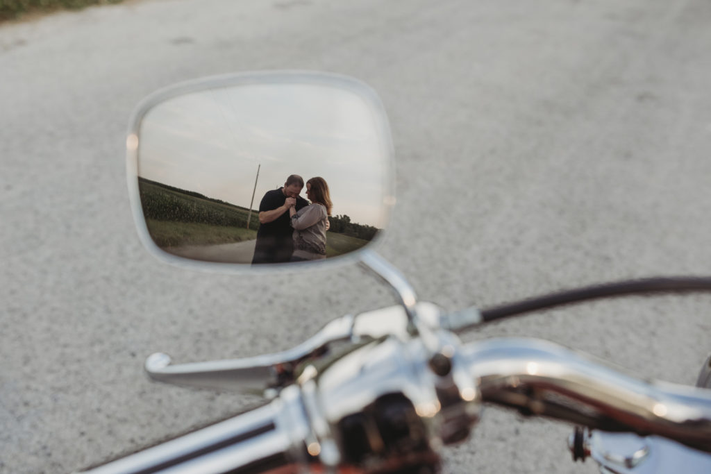 Brandon and Rachel are pictured in the side mirror of Brandon's motorcycle.