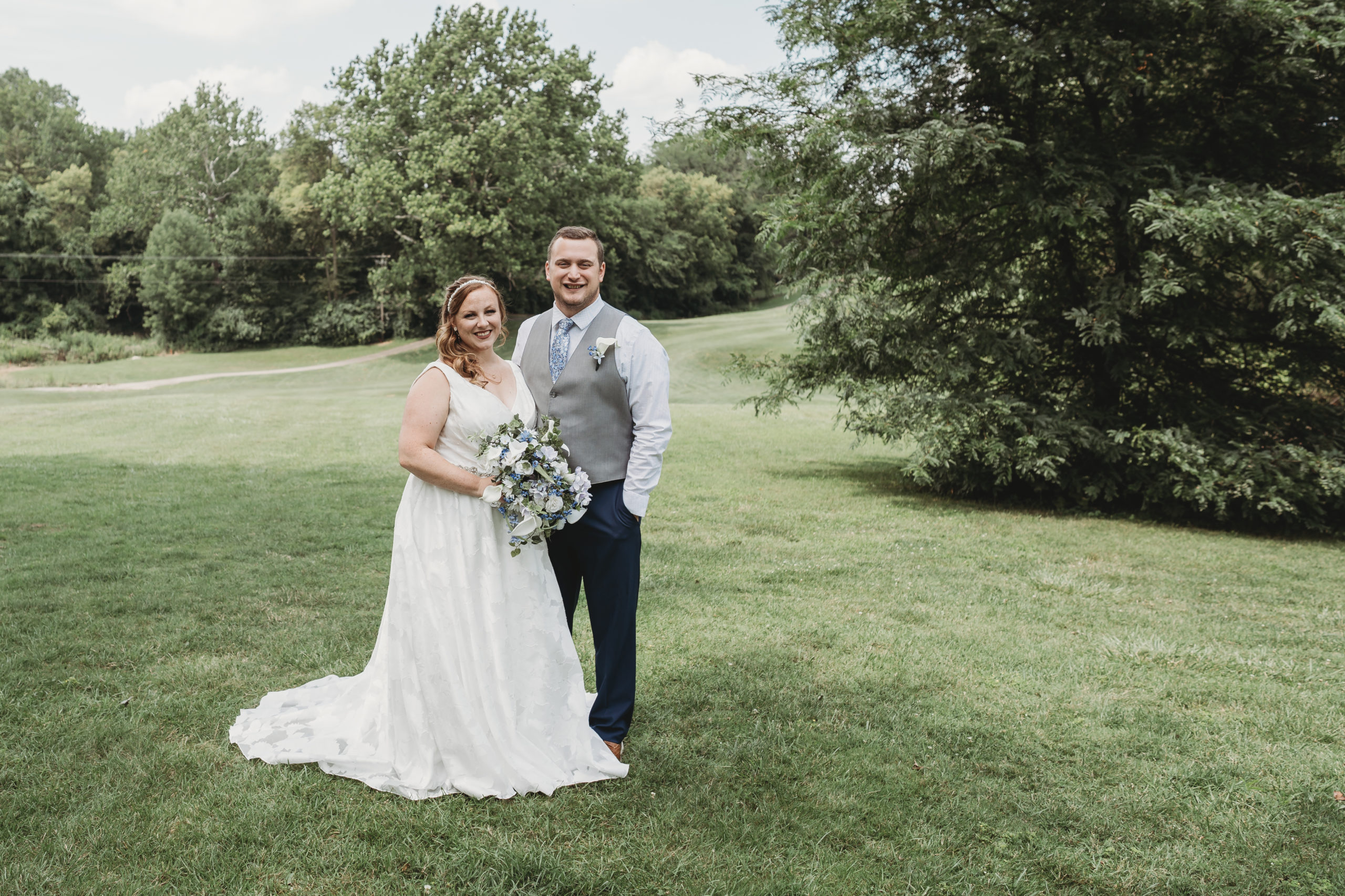Bride and Groom stand together on a picturesque golf course