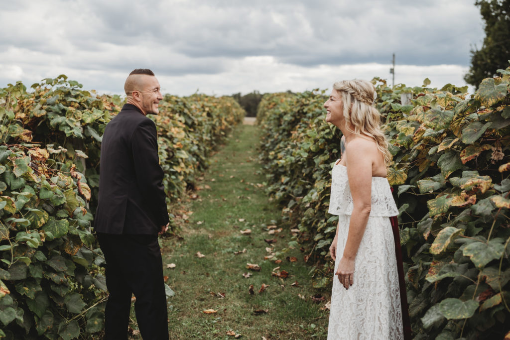 Groom and Bride share their first look in a row of grape vines at White Shutter Winery outside of Nevada, Ohio