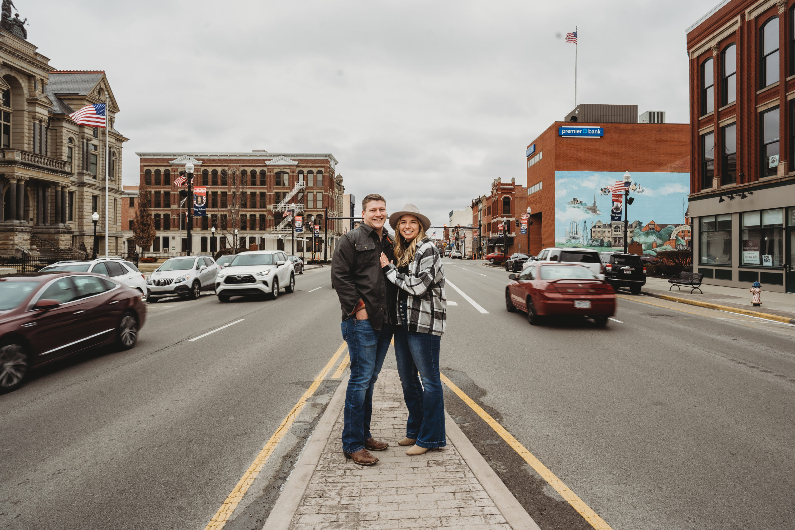 Engagement session in downtown Findlay with couple standing in the middle of a busy road