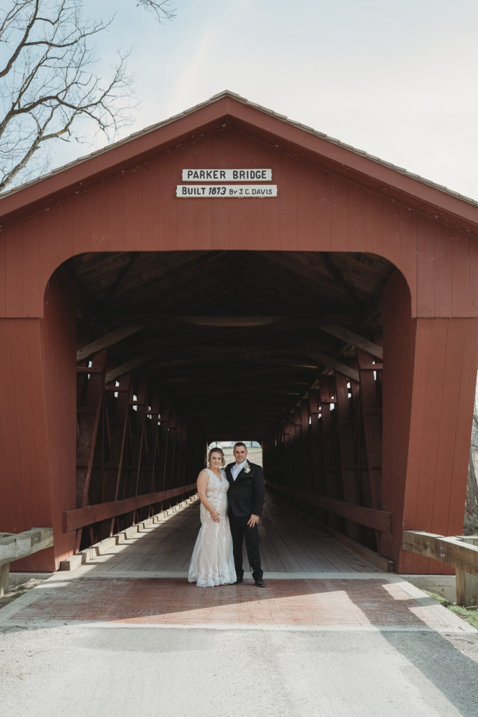 Bride and groom pose under the Parker Covered Bridge outside of Upper Sandusky, Ohio